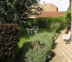 a patio with a table and chairs in a garden at La Clef des Champs - Proche Colmar in Biesheim