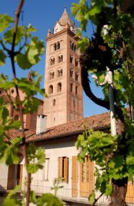 una torre alta con un orologio in cima a un edificio di Albergo San Lorenzo ad Alba