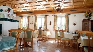 a restaurant with tables and chairs and a chandelier at Hotel Landhaus Fuhrgassl-Huber in Vienna