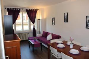 ein Wohnzimmer mit einem lila Sofa und einem Tisch in der Unterkunft Go Native Prague Apartment in Prag