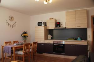 a kitchen with a table and a kitchen with a stove at Ferienwohnung am Erlermuhlenbach in Voigtsdorf