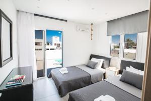 a bedroom with two beds and a view of the ocean at Evelina Apartment in Protaras