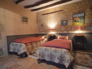 a bedroom with two beds and a stone wall at Holiday home near the forest in Lern in Lerné