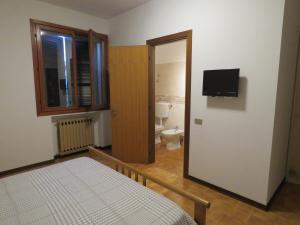a bedroom with a bed and a bathroom with a toilet at Casa Bellodi in Novi di Modena