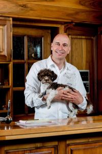 a chef holding a dog on a counter at Swiss Chalet-Style Hotel Walliser Spycher in Riederalp