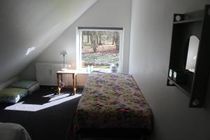 Un dormitorio con una cama con una mesa y una ventana. en Skovgårdens Apartment, en Grindsted