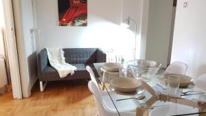 a dining room with a glass table and white chairs at Errathens Wheat Apartment - Athens Center, 3 BD, 1 BATH in Athens