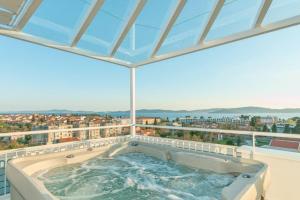 bañera de hidromasaje en el balcón de un edificio en Sunset Penthouse Apartment with Jacuzzi and Seaview, en Zadar