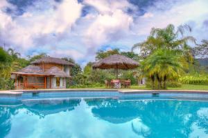 a beach scene with a pool and a balcony at Terrabambu Lodge in Mindo