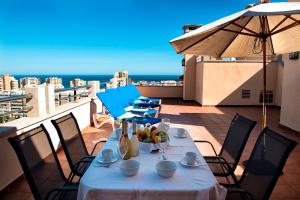 - une table avec un bol de fruits sur le balcon dans l'établissement Apartamentos Mediterráneo Real, à Fuengirola