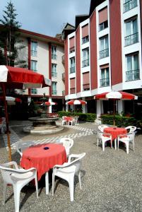 モンテロッソ・アル・マーレにあるホテル 5 テッレの建物前の傘付きテーブルと椅子