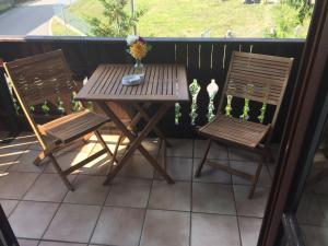- Balcón con mesa de madera y 2 sillas en Gästehaus Eder en Schrobenhausen