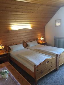 1 Schlafzimmer mit 2 Betten in einem Holzzimmer in der Unterkunft Gästehaus Eder in Schrobenhausen