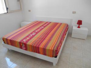 ガリポリにあるBilocale al mare Baia Verdeのベッド(カラフルな毛布付)