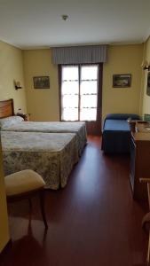 A bed or beds in a room at Hotel Valle Las Luiñas