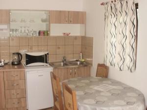 a small kitchen with a table and a sink at Guest House Korana in Korana