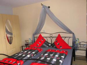 a bedroom with a black and red bed with red pillows at Ferienwohnung Abendsonne am Europa-Park in Rheinhausen