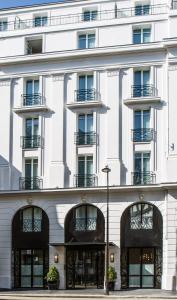 a white building with windows and balconies at Le Tsuba Hotel in Paris