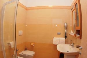a bathroom with a shower and a toilet and a sink at Hotel Yria in Vieste