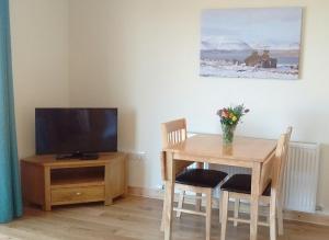 a dining room with a table and a television at Fara 2 room, 1 bedroom - B&B private suite in Kirkwall