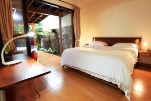 een slaapkamer met een bed, een tafel en een raam bij Spring Hill Hotel Ruteng in Ruteng