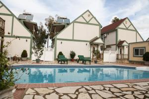a villa with a swimming pool in front of a building at Ermolaos Hillside Villas in Lixouri