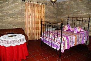 Un dormitorio con una cama y una mesa. en Hostal la Encina en El Real de la Jara