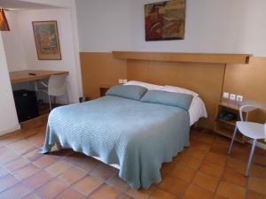 a bedroom with a bed with a blue blanket at Hôtel des Templiers in Collioure