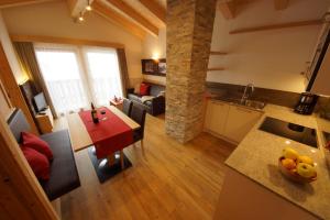 a kitchen and living room with a table and a dining room at Ciasa Wallis in Badia