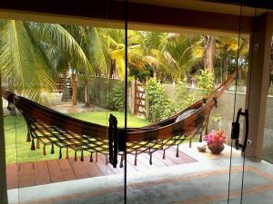a hammock in a house with a view of a courtyard at Recanto Ubuntu in Japaratinga