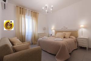 a bedroom with a bed and a chair and a chandelier at Holiday & House - Imparato Vacanze Prestige Mondello in Mondello