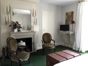 sala de estar con 2 sillas y chimenea en Chambres d'Hôtes Grand Bouy, en Berry-Bouy
