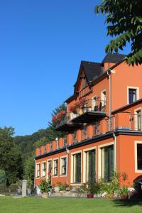 um edifício laranja com flores nas varandas em Dampfschiffhotel em Stadt Wehlen