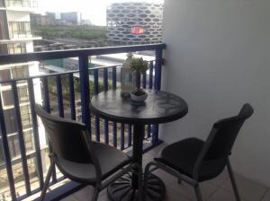 een kleine tafel en 2 stoelen op een balkon bij Sea Residences MoA Manila in Manilla