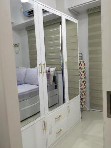 um quarto com um grande armário branco com espelhos em Sea Residences MoA Manila em Manilla