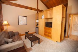 a living room with a couch and a flat screen tv at Timberland Inn in Kenora