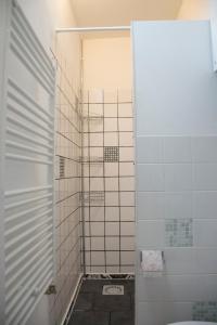 a bathroom with a shower with white tiles at Yokistay in The Hague