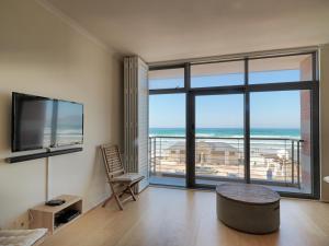 ein Wohnzimmer mit Blick auf das Meer in der Unterkunft Surferscorner Self Catering Apartments in Muizenberg + 62 Fotos