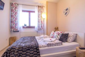 1 dormitorio con cama con almohadas y ventana en Apartamenty Smrekowa Tatry Zakopane, en Zakopane