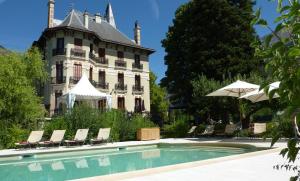 um edifício com piscina em frente a uma casa em Villa Morelia em Jausiers