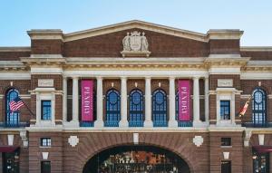 a large brick building with pink banners on it at Sagamore Pendry Baltimore in Baltimore