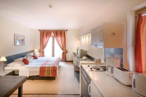 a hotel room with a bed and a kitchen at Hotel Kalma, Kalma Villa, Apart Hotel in Hévíz