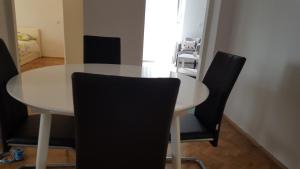 - une table à manger blanche avec des chaises noires dans l'établissement Apartment Sibenik with free parking, à Šibenik