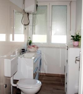 uma casa de banho branca com um WC e um lavatório em Apartment Sibenik with free parking em Šibenik