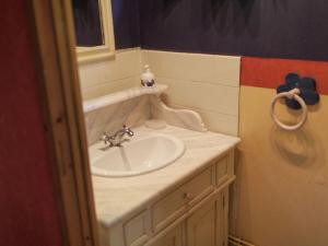 a bathroom with a white sink and a mirror at Lovely Holiday Home in Le Ponchel with Garden Pond in Le Ponchel