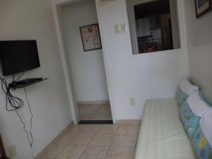 uma sala de estar com uma televisão e um sofá em Apartamento Boa Viagem no Recife