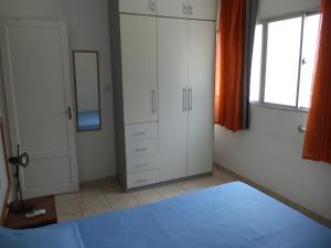 a bedroom with white cabinets and a mirror at Apartamento Boa Viagem in Recife