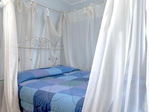 a bedroom with a bed with white curtains at Belvilla by OYO Villa Valtopina in Valtopina