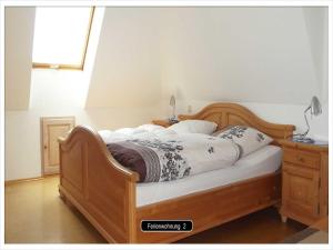 ein Schlafzimmer mit einem Holzbett, einer Kommode und einem Fenster in der Unterkunft Grundhof in Stegen