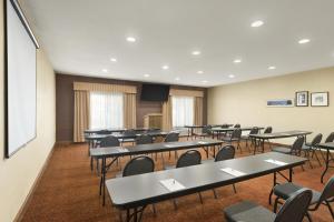 a conference room with tables and chairs and a screen at Country Inn & Suites by Radisson, Topeka West, KS in Topeka